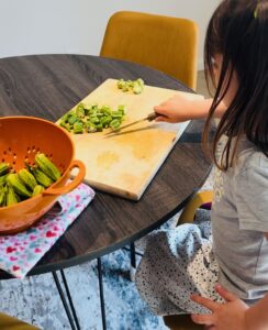 child preparing vegetables, helping to cook dinner